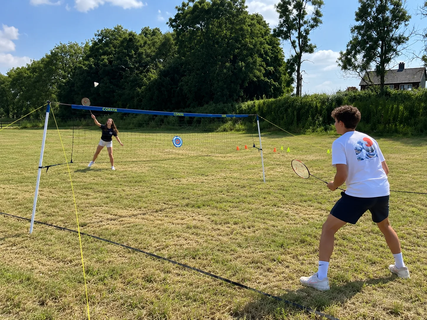 Two teenagers playing badminton outdoors
